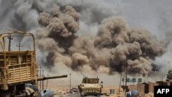 FILE - Smoke billows as Iraqi forces advance towards Al-Ayadieh village, the last remaining active front line near Tal Afar, during an operation to retake the city from the Islamic State (IS) group on August 29, 2017.