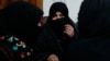 FILE - In this Feb. 18, 2019, photo, Alissa, who faced domestic violence, center, speaks during an interview with the Associated Press at a women's shelter office in Herat, Afghanistan.