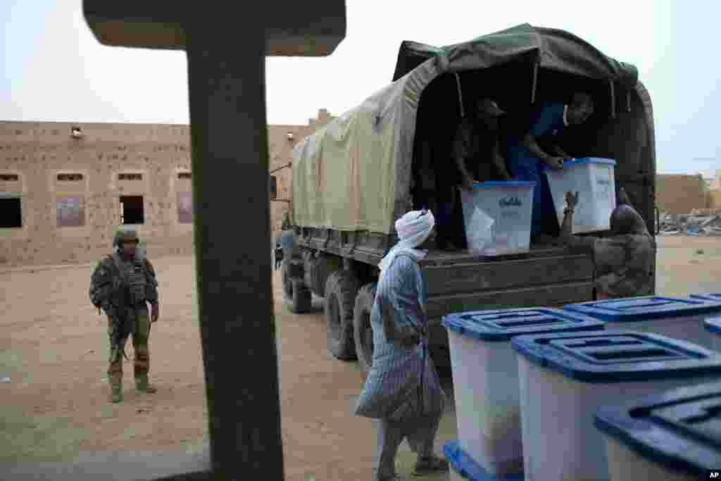 A French soldier stands guard as election workers unload ballot boxes containing election materials at the main polling station in Kidal, Mali, July 28, 2013. 