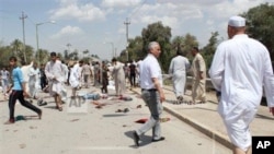 Warga Irak berkumpul di lokasi terjadinya ledakan bom di Baqouba, utara Baghdad, Irak (17/5). Seorang pejabat kepolisian anti-teror dan keluarganya dilaporkan tewas diserang kawanan bersenjata yang menerobos masuk ke rumahnya di kawasan pinggiran Baghdad, Sabtu (18/5). 
