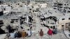 Warga Palestina melihat rumah-rumah yang hancur akibat serangan Israel selama konflik, di tengah gencatan senjata sementara antara Israel dan Hamas, di kamp pengungsi Khan Younis, di selatan Jalur Gaza, 29 November 2023. (Foto: REUTERS/Mohammed Salem)