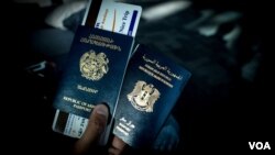 Seorang warga Suriah keturunan Armenia memegang paspor dwi kewarganegaraannya, Suraiah dan Armenia, di bandara Zvartnots, (Foto: dok - VOA/D. Markosian).