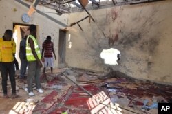 People inspect a damaged mosque following an explosion in Maiduguri, Nigeria, Oct. 23, 2015. Boko Haram is suspected to be behind bombing.