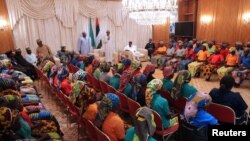 Le président Mahammadu Buhari parle avec les lycéennes de Chibok libérées à Abuja, Nigeria, 7 mai 2017.