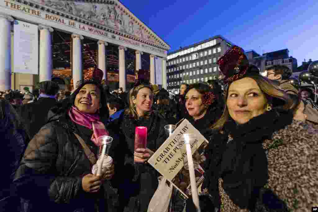 Warga Brussels, Belgia, memegang lilin dalam protes untuk solidaritas terhadap demonstran Women's March di Washington (21/1). (AP/Geert Vanden Wijngaert)