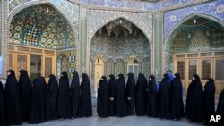 Iranian women stand in line at a polling station during the parliamentary and Experts Assembly elections in Qom, 125 kilometers (78 miles) south of the capital Tehran, Iran, Friday, Feb. 26, 2016. (AP Photo/Ebrahim Noroozi)