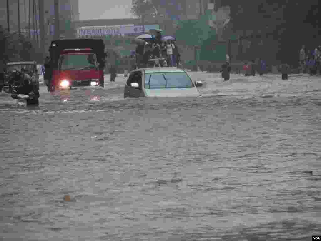 A car tries to drive through Jakarta's flooded streets, Indonesia, January 17, 2013. (VOA Indonesian Service)