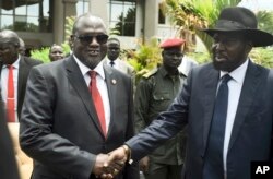 FILE - South Sudan's First Vice President Riek Machar, left, and President Salva Kiir shake hands following the first meeting of a new transitional coalition government, in Juba, South Sudan, April 29, 2016.
