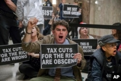 Protesters shout their disapproval of the Republican tax bill outside the Senate Budget Committee hearing room on Capitol Hill in Washington, Nov. 28, 2017.