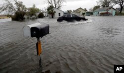 A driver moves through flood waters left behind by Hurricane Harvey, in Aransas Pass, Texas, Aug. 26, 2017.