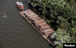 FILE - Logs that were illegally cut from Amazon rainforest are transported on a barge on the Tapajos river, a tributary of the Amazon, near the city of Santarem, Para state, April 18, 2013.