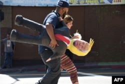 FILE - A Latino couple walk with a pinata of Republican presidential candidate Donald Trump in downtown Los Angeles, Sept. 23, 2015. "The Hispanic community in general feels abandoned by the Republican party,” one Prince William County resident says.