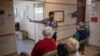 Home manager Theresa Swart, center, explains to elderly guests of the retirement home how the Pfizer vaccine works during a vaccination run near Klerksdorp, South Africa on May 19, 2021.
