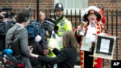 Tony Appleton, a town crier, announces to the assembled media the birth of the royal baby, outside the Lindo Wing, St. Mary's Hospital, London, Saturday, May 2, 2015.