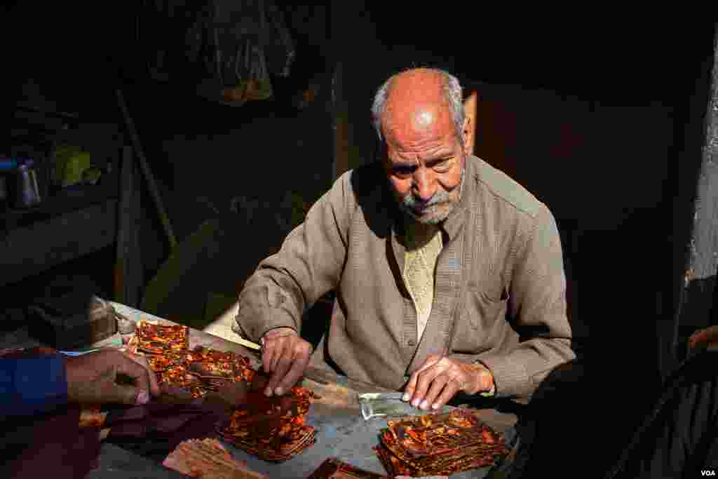 Ahmed Ibrahim, a 78-year-old handmade leather designer for wallets, says "I do not think this profession will last for long, the young generations are hoping to earn easier money by driving toktoks." (H. Elrasam/VOA)