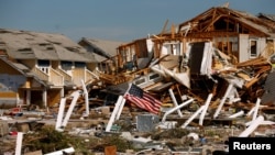 An American flag flies amongst rubble left in the aftermath of Hurricane Michael in Mexico Beach, Florida, Oct. 11, 2018.