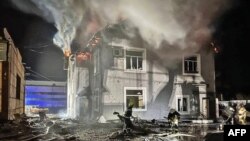 Tim penyelamat bekerja di sebelah gedung administrasi yang rusak akibat serangan pesawat tak berawak di wilayah Kyiv, 30 Januari 2024. (Handout/LAYANAN DARURAT UKRAINIAN/AFP)