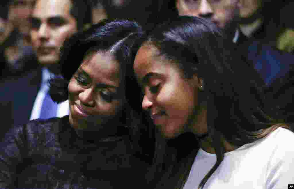 First lady Michelle Obama and daughter Malia lean into one another as they listen to President Barack Obama speak during his farewell address at McCormick Place in Chicago, Jan. 10, 2017. 