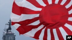 FILE - In this Oct. 14, 2012, photo, Japan Maritime Self-Defense Force (JMSDF) escort ship Kurama, left, navigates behind destroyer Yudachi, with a rising sun flag, during a fleet review in water off Sagami Bay, south of Tokyo. 