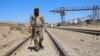 A Taliban security official walks at the construction site of railway tracks during the inauguration ceremony of the TAPI pipeline project, at the Turghundi border post in Kushk district of Herat province in Afghanistan on Sept. 11, 2024.