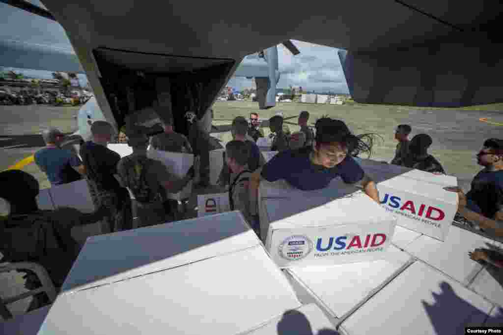  Sailors assigned to the U.S. Navy's forward-deployed aircraft carrier USS George Washington (CVN 73) and Marines assigned to the 3d Marine Expeditionary Brigade load boxes of supplies into a U.S. Marine Corps MV-22 Osprey from the Marine Medium Tiltrotor
