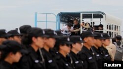 Tim SWAT polisi China berbaris sebagai tersangka penipuan telekomunikasi tiba sebelum deportasi mereka ke China di Bandara Internasional Phnom Penh, Kamboja 24 Juni 2016. (Foto: dok).