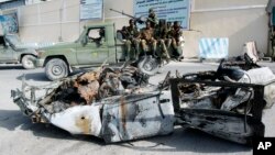 Tentara Somalia mengamati puing-puing mobil yang meledak di komplek istana Presiden di Mogadishu (8/7).