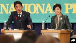 Ruling Liberal Democratic Party leader and Japan's Prime Minister Shinzo Abe, left, speaks as Party of Hope leader Yuriko Koike, listens during the party leaders' debate for the Oct. 22 lower house election in Tokyo, Oct. 8, 2017.