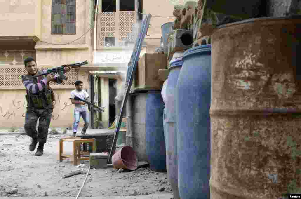 A Free Syrian Army fighter fires back at the Syrian Army, Deir al-Zor, May 19, 2013. 