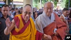 FILE - Tibetan spiritual leader the Dalai Lama, left, greets devotees as he arrives to give a talk at the Tsuglakhang temple in Dharmsala, India, Sept. 7, 2015.