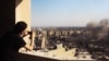 FILE - In this image provided by Shaam News Network, a Syrian citizen journalist documents Syrian forces shelling in Homs, Syria, July 24, 2012.