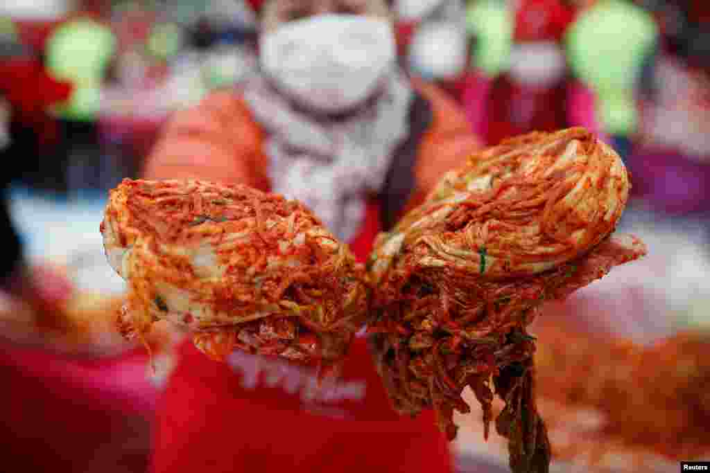 Seorang wanita berpose dengan makanan tradisional ‘Kimchi’ selama Festival Kimchi di Seoul. Seoul, Korea Selatan.