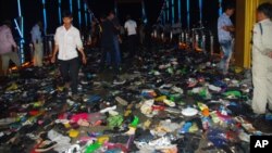 Cambodians walk through piles of shoes on a newly-built bridge where the worst stampede in their country's modern history happened, killing at least 345 people on Monday, November 22, 2010.