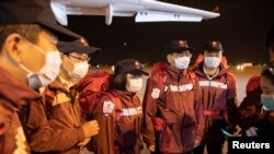 Medical experts from China stand at the Nikola Tesla airport after arriving with medical supplies to help the country's fight against the coronavirus in Belgrade, Serbia, March 21, 2020.