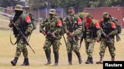FILE - Defected members of the Colombian guerrilla group ELN walk to a military base to surrender and handover their weapons, in Cali, July 16, 2013.