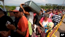 FILE - Venezuelans cross the International Simon Bolivar bridge into the Colombia, Feb. 21, 2018.