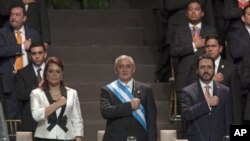 Guatemala’s President Otto Perez Molina, center, his Vice President Roxana Baldetti, left, and Congress' President Gudy Rivera listen to their national anthem during Perez's Molina and Baldetti's swearing-in ceremony in Guatemala City, January 14, 2012.