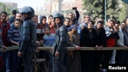 Des badauds sur le site de l'attaque d'une église dans le district de Helwan au sud du Caire, en Egypte, le 29 décembre 2017.