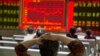 An investor watches a display of stock prices at a brokerage in Beijing, Aug. 21, 2015. 