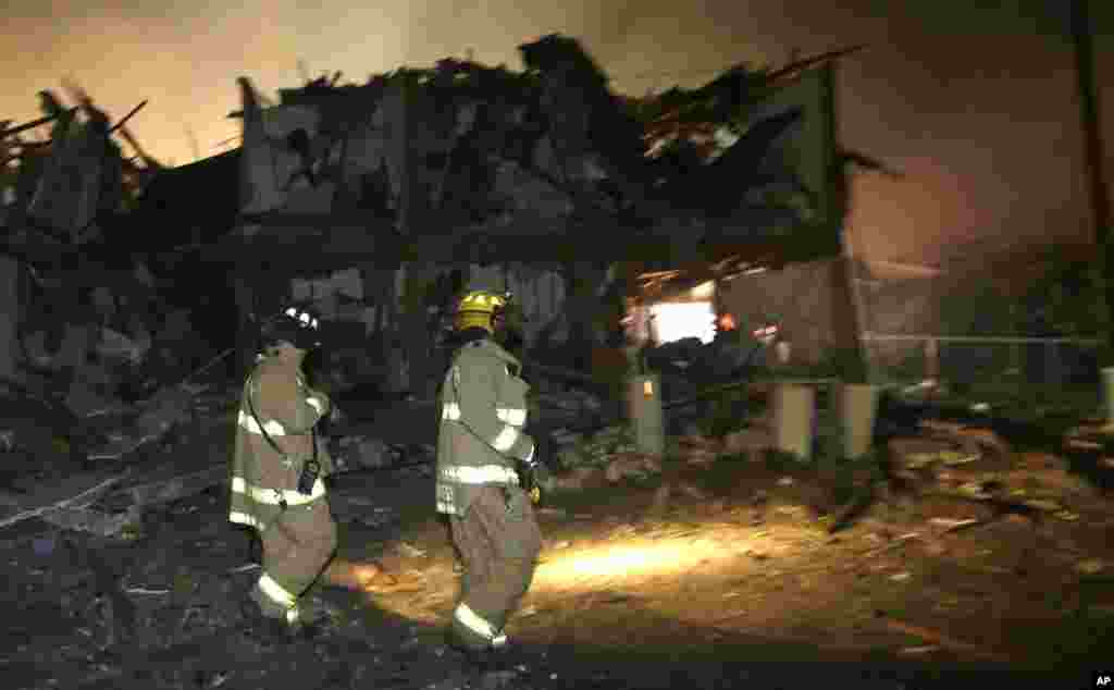 Firefighters walk next to a destroyed apartment complex near a fertilizer plant that exploded earlier in West, Texas, in this photo taken early morning April 18, 2013.