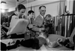 Joseph Biden Jr., left, offers words of encouragement to his bedridden son, Beau, before Biden was sworn in as a U.S. Senator from Delaware, Jan. 5, 1973. Biden's other son, Hunter, talks with Robert Hunter, Biden's father-in-law.