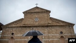 A Catholic worshipper arrives for the Easter mass held at the Roman Catholic cathedral of the Lady Helper in the town of Prizren, Southern Kosovo, on Apr. 4, 2021.