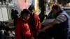 Migrant shelter director Jose Garcia, right, gives a few coins to two men from Guatemala on their way to cross into the United States in Tijuana, Mexico, Nov. 14, 2016.