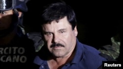 FILE - Recaptured drug lord Joaquin 'El Chapo' Guzman is escorted by soldiers at the hangar belonging to the office of the Attorney General in Mexico City, Mexico, Jan. 8, 2016.