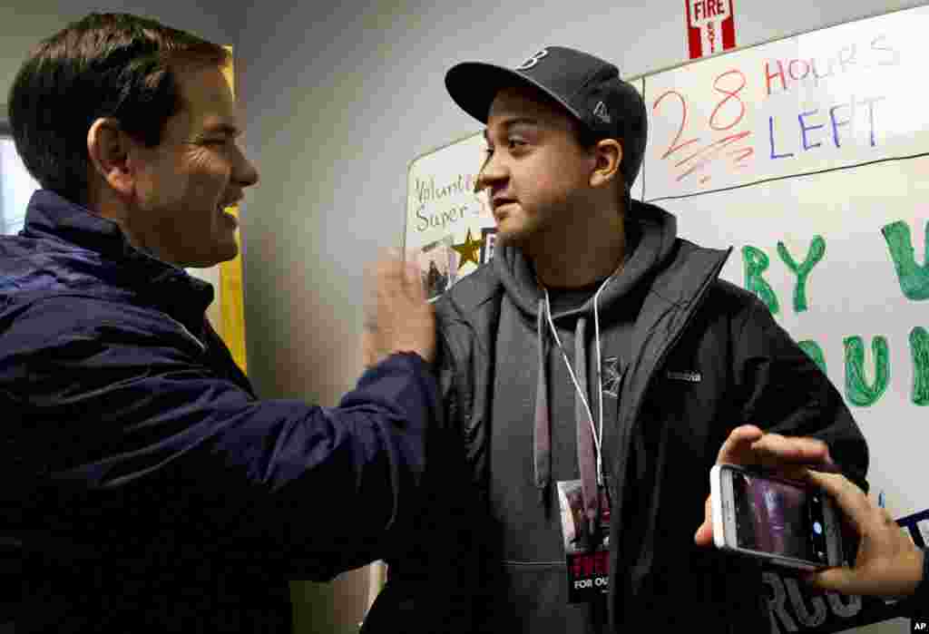 Kandidat capres dari Partai Republik Marco Rubio, berterima kasih pada seorang sukarelawan Chris Ward, 26, dari Tampa, Florida di samping papan tulis yang menunjukkan waktu yang tersisa sebelum pemilihan pendahuluan New Hampshire di markas besar kampanyenya di Manchester, N.H., 8 Februari 2016.