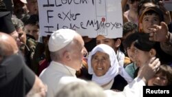 Paus Fransiskus menyambut kaum migran dan pengungsi di kamp pengungsi Moria dekat pelabuhan Mytilene. Pulau Lesbos, Yunani. (foto: REUTERS/Filippo Monteforte)