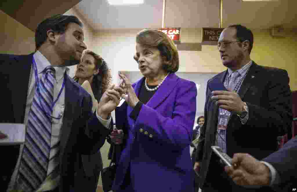 La présidente du comité du renseignement du Sénat, la sénatrice Dianne Feinstein (Californie) est poursuivie par des journalistes au Capitole à Washington, 9 décembre 2014. Ce comité vient de publier un rapport sur les techniques d'interrogatoire brutales de la CIA dans des installations secrètes basées à l'étranger après les attaques terroristes du 11 septembre 2001. 