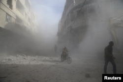People are seen during shelling in the town of Hamoria, eastern Ghouta in Damascus, Syria, Dec. 3, 2017.