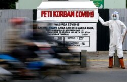 Peti mati dan boneka yang mengenakan pakaian pelindung diri agar terlihat seperti petugas kesehatan terlihat di tempat umum untuk memperingatkan orang-orang tentang bahaya virus corona, akarta, 18 Agustus 2020. (Foto: Reuters)