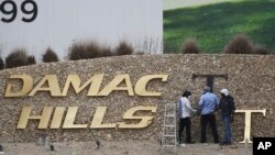 FILE- In this Sunday, Feb. 12, 2017 file photo, workers re-install a gold letter sign for the Trump International Golf Club in Dubai, United Arab Emirates.